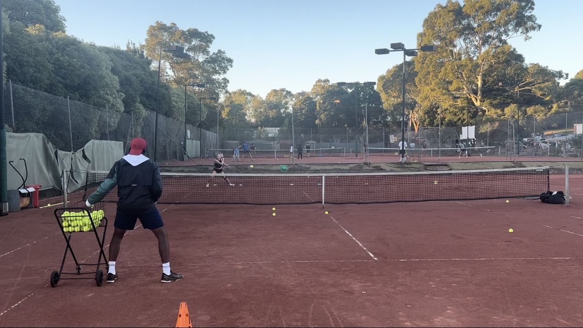 Tennis coach giving a one-on-one private lesson at Holy Saviour Tennis Club